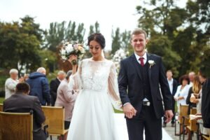 Happy groom and beautiful bride wedding ceremony under the arch decorated with flowers. Wedding day.